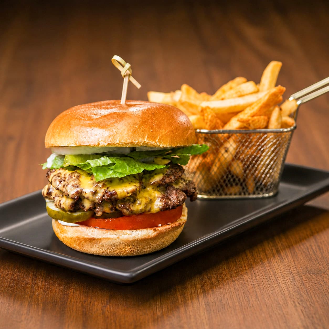 House Stack burger with french fries on a black plate