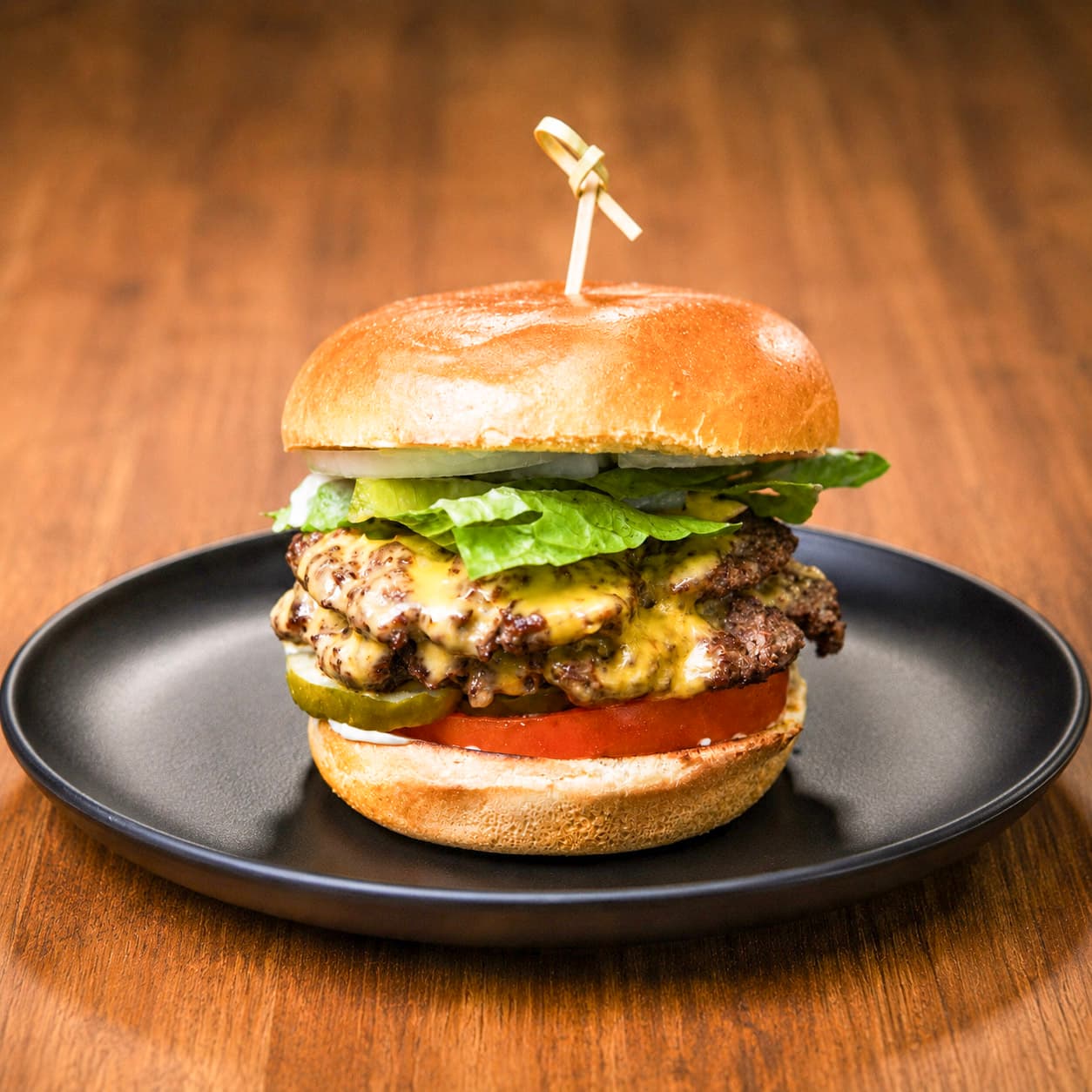 House Stack burger with American cheese, lettuce, tomato, red onion, and pickles